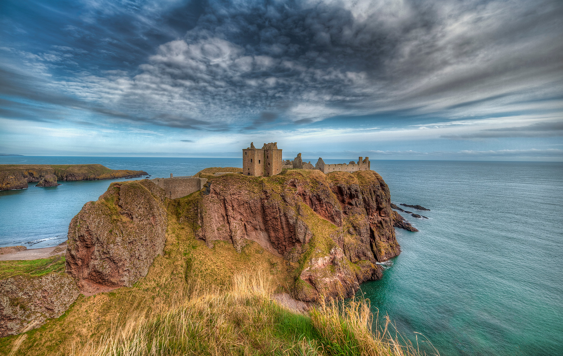 A visual representation of the meaning of Aird | A High Point in the sea of sameness. A High Place, Promontory or Headland is an image of Castle Dunnottar to the west of Inverness near the north end of Loch Ness where Gorge Aird was born.  